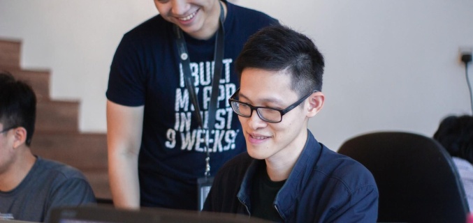 Two people looking at a computer screen and smiling