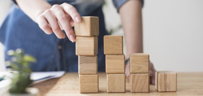 Man stacks wooden building blocks