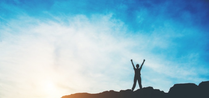Man with raised arms on a mountain